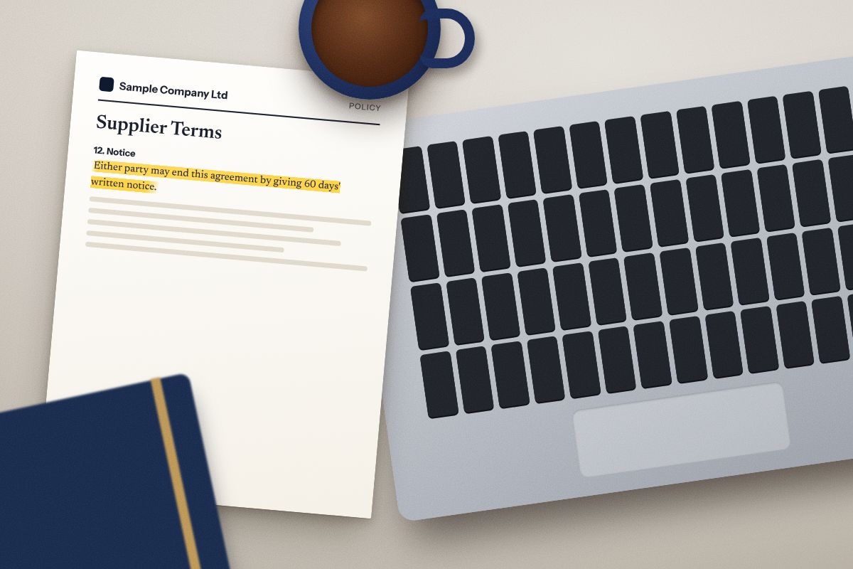 A desk with a laptop and a supplier terms document, its notice clause highlighted.